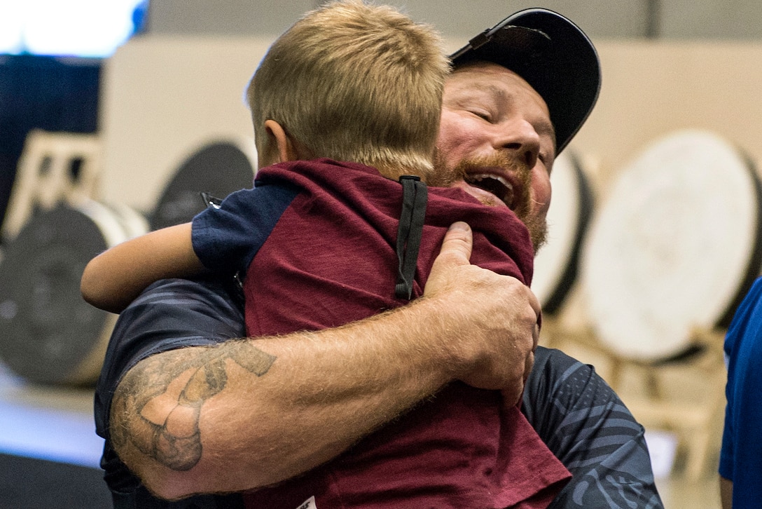 Army veteran Joshua Lindstrom, a member of the U.S. Special Operations Command team, hugs his 8-year-old son after winning gold in an archery event during the 2017 Department of Defense Warrior Games in Chicago, July 3, 2017. DoD photo by EJ Hersom