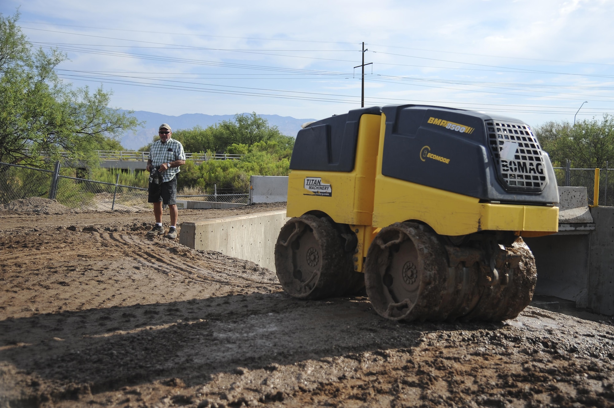 Douglas Burke, 355th Civil Engineer Squadron heavy equipment operator, remotely controls a sheepsfoot roller to flatten dirt at Davis-Monthan Air Force Base, Ariz., June 8, 2017. The 355th Civil Engineer Squadron pavements and equipment shop used approximately 2,500 tons of dirt to help reconstruct Atterbury Wash, a natural creek on the installation, in preparation for monsoon season. (U.S. Air Force photo by Senior Airman Mya M. Crosby)