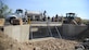 U.S. Air Force 355th Civil Engineer Squadron pavements and equipment Airmen, also known as the Dirt Boyz, pose on top of the newly-reconstructed Atterbury Wash and bridge at Davis-Monthan Air Force Base, Ariz., June 28, 2017. The Dirt Boyz spent approximately 2,900 man hours and $157,000 on the project. (U.S. Air Force photo by Senior Airman Mya M. Crosby)