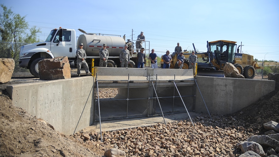 U.S. Air Force 355th Civil Engineer Squadron pavements and equipment Airmen, also known as the Dirt Boyz, pose on top of the newly-reconstructed Atterbury Wash and bridge at Davis-Monthan Air Force Base, Ariz., June 28, 2017. The Dirt Boyz spent approximately 2,900 man hours and $157,000 on the project. (U.S. Air Force photo by Senior Airman Mya M. Crosby)