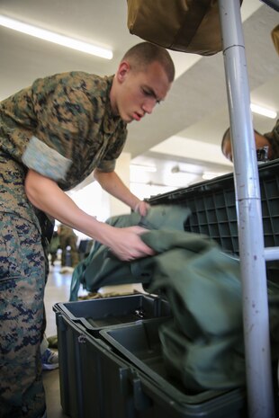 A recruit from Kilo Company, 3rd Recruit Training Battalion, grabs his sea bag during pick up at Marine Corps Recruit Depot San Diego, May 26. The recruits use their sea bags to stow away gear. In the first hours recruits are with their drill instructors they learn the rules and regulations of recruit training, covering everything from how to act in the squad bay to how to speak to the drill instructors. Annually, more than 17,000 males recruited from the Western Recruiting Region are trained at MCRD San Diego. Kilo Company is scheduled to graduate Aug. 18.