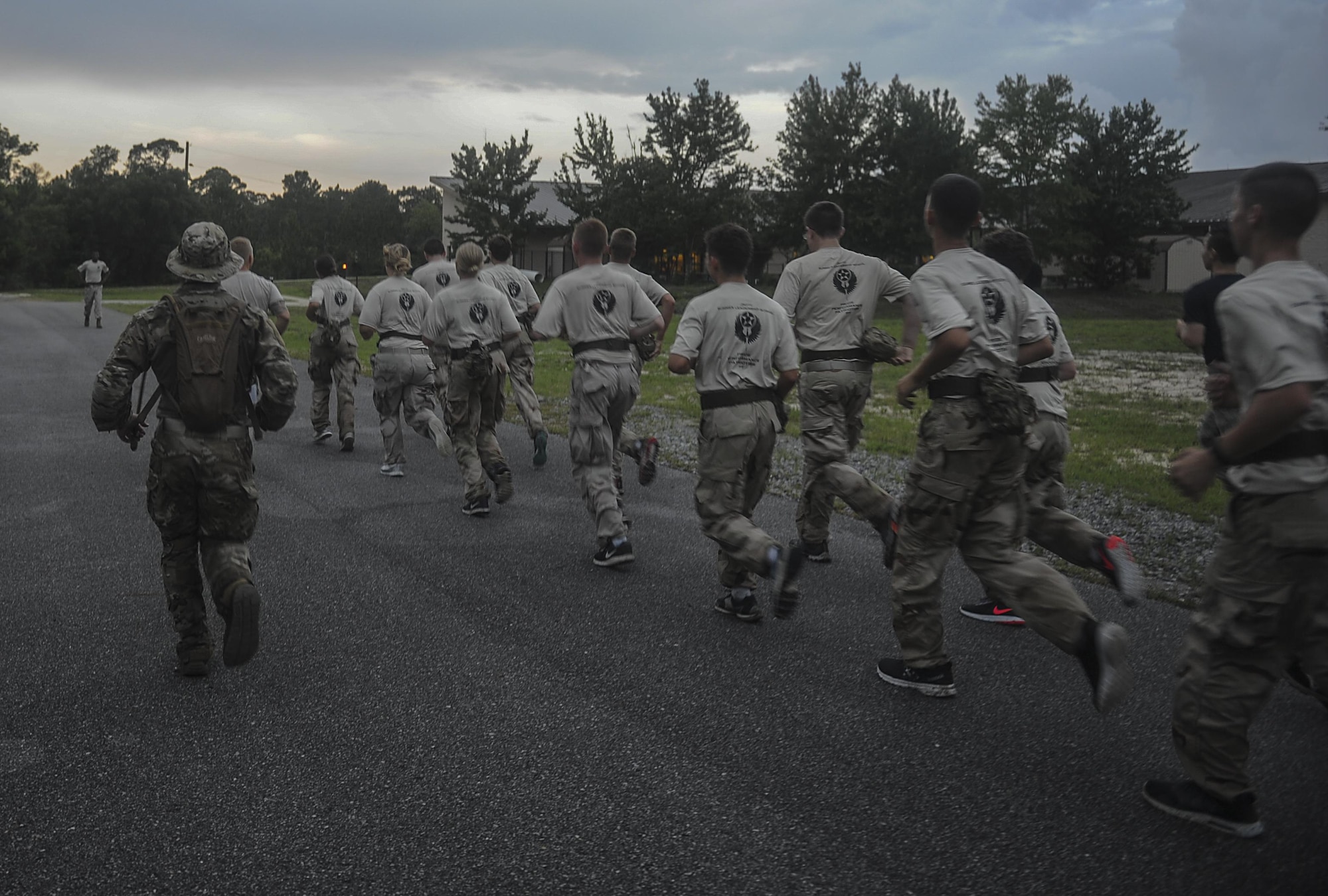 A Special Tactics Airman with the 23rd Special Tactics Squadron leads Junior ROTC cadets on a formation run toward an obstable during a Monster Mash at Hurlburt Field, Fla., June 30, 2017. A Monster Mash is a competition designed to strengthen team-building and leadership skills. (U.S. Air Force photo by Airman 1st Class Rachel Yates)