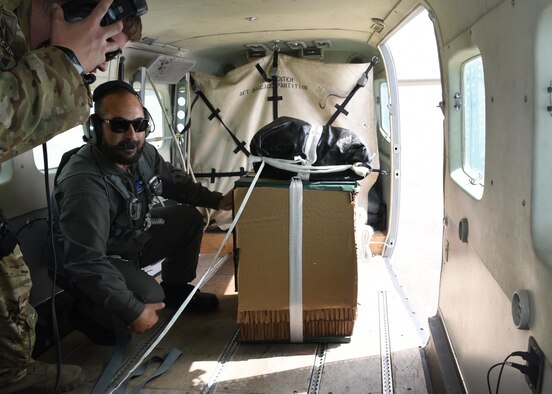 An Afghan Air Force C-208 pilot, prepares to deliver supplies, over Southeast, Afghanistan, as Tech. Sgt. Brian Wahl, Train, Advise, Assist Command-Air, 538th Air Expeditionary Advisory Squadron C-208 loadmaster advisor, stands by for assistance during an aerial resupply mission on June 28, 2017. This was the first operational airdrop performed by AAF aircrew. The AAF successfully delivered 800 pounds of supplies to Afghan Border Police at their coordinated drop zone. (U.S. Air Force photo by Tech. Sgt. Veronica Pierce)