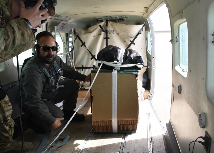 An Afghan air force C-208 pilot, prepares to deliver supplies June 28, 2017, over Southeast Afghanistan, as Tech. Sgt. Brian Wahl, Train, Advise, Assist Command-Air, 538th Air Expeditionary Advisory Squadron C-208 loadmaster advisor, stands by for assistance during an aerial resupply mission. This was the first operational airdrop performed by AAF aircrew. The AAF successfully delivered 800 pounds of supplies to Afghan Border Police at their coordinated drop zone. (U.S. Air Force photo by Tech. Sgt. Veronica Pierce)