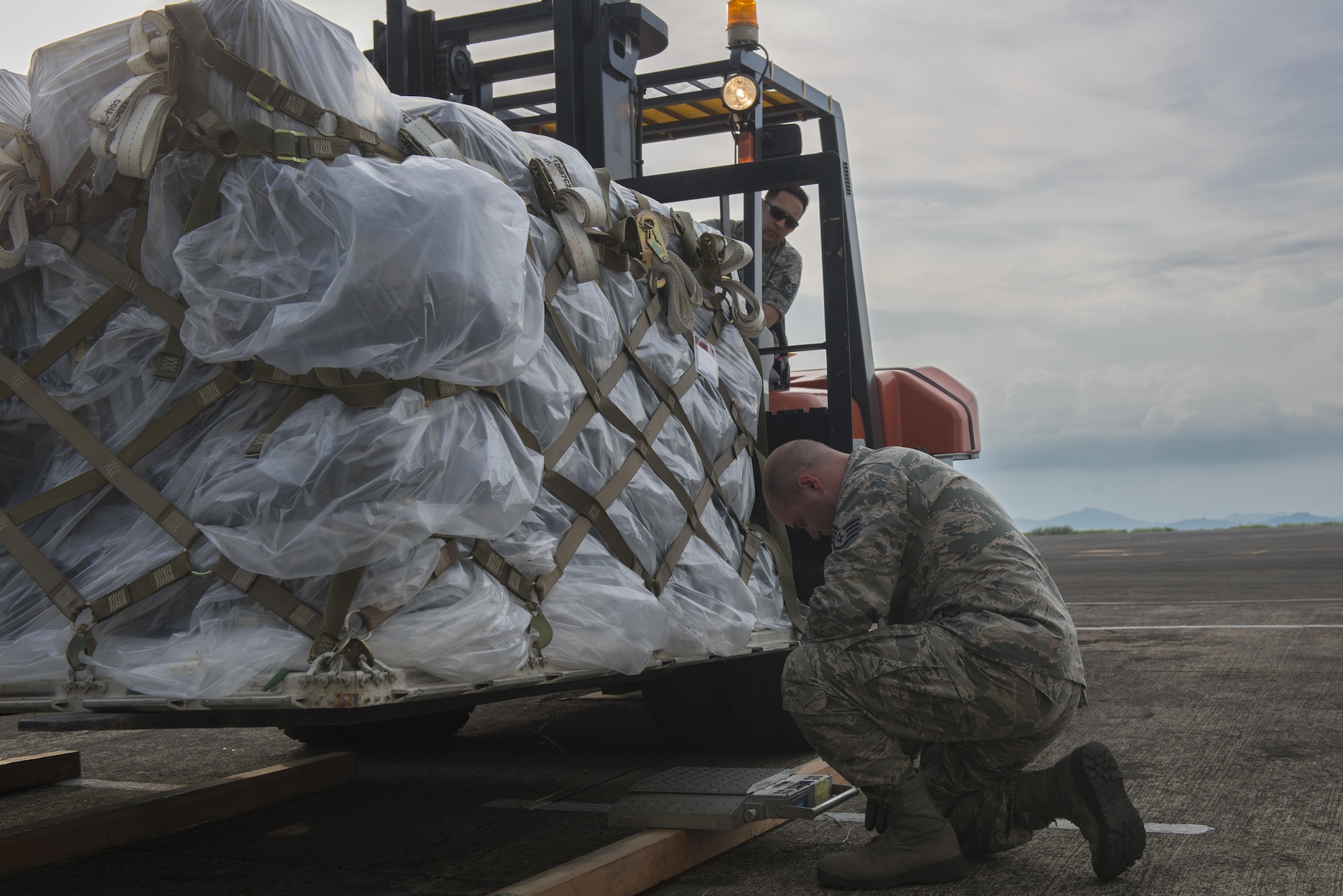 From left, Tech. Sgt. Phillip Eyer, 374th Logistics and Readiness Squadron joint inspector, and Staff Sgt. Brandon Inhat, 374 LRS flight combat mobility operations technician, inspect a cargo pallet during Yokota Air Base’s first C-130J Super Hercules operational mission, June 30, 2017, at Manila, Philippines. The mission highlighted Yokota’s C-130J increased airlift capabilities. (U.S. Air Force photo by Airman 1st Class Juan Torres)