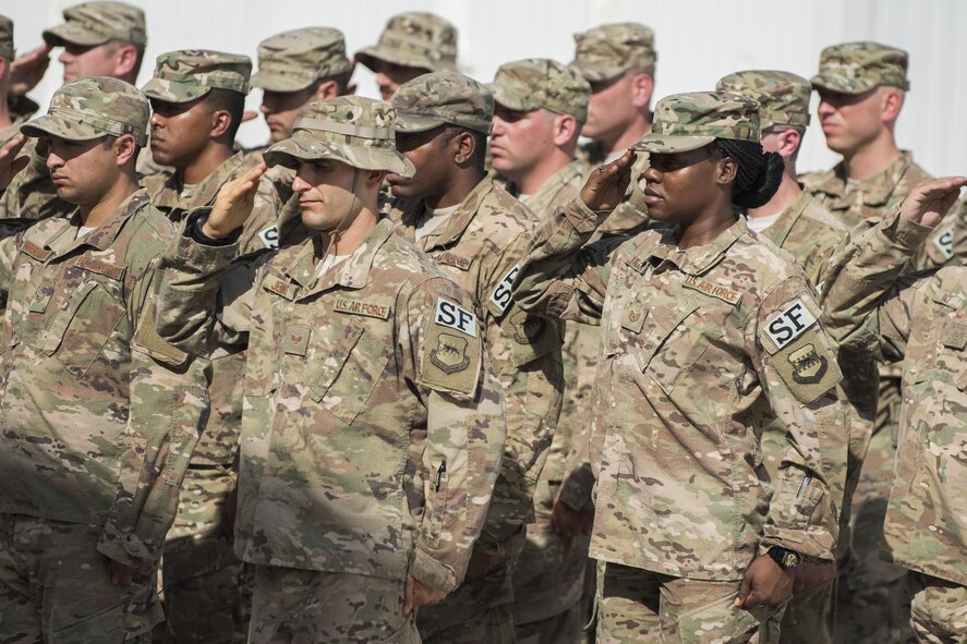 Members of the 332nd Expeditionary Security Force Squadron render a salute during a retreat ceremony June 30, 2017, in Southwest Asia. The ceremony was held to honor and remember service members who have made the ultimate sacrifice. (U.S. Air Force photo/Senior Airman Damon Kasberg)