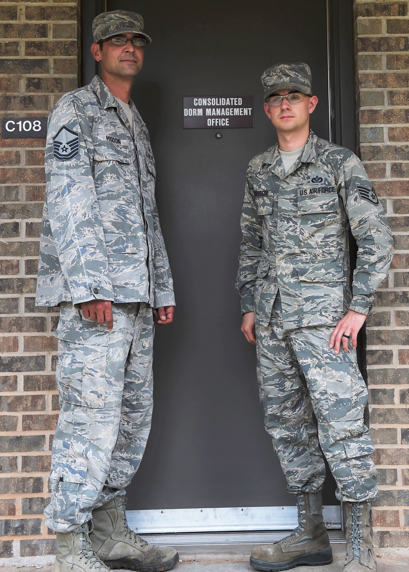 U.S. Air Force Master Sgt. Christopher Higdon and U.S. Air Force Staff Sgt. William Harrison, 97th CES Airmen dorm leaders, pose for a photo in front of the dorm managers office, June 30, 2017, at Altus Air Force Base, Oklahoma. Dorm management works to improve dorm quality of life for the first-term Airmen living on base by preforming multiple tasks to maintain the longevity of the Altus AFB dorms. (U.S. Air Force Photo by Airman 1st Class Jackson N. Haddon/Released).