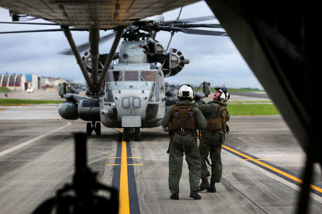 Marine Corps crew chiefs perform final checks on their CH-53E Super Stallion helicopters before participating in aerial gunnery training at Camp Foster, Okinawa, Japan, June 27, 2017. Marine Corps photo by Sgt. Rebecca L. Floto