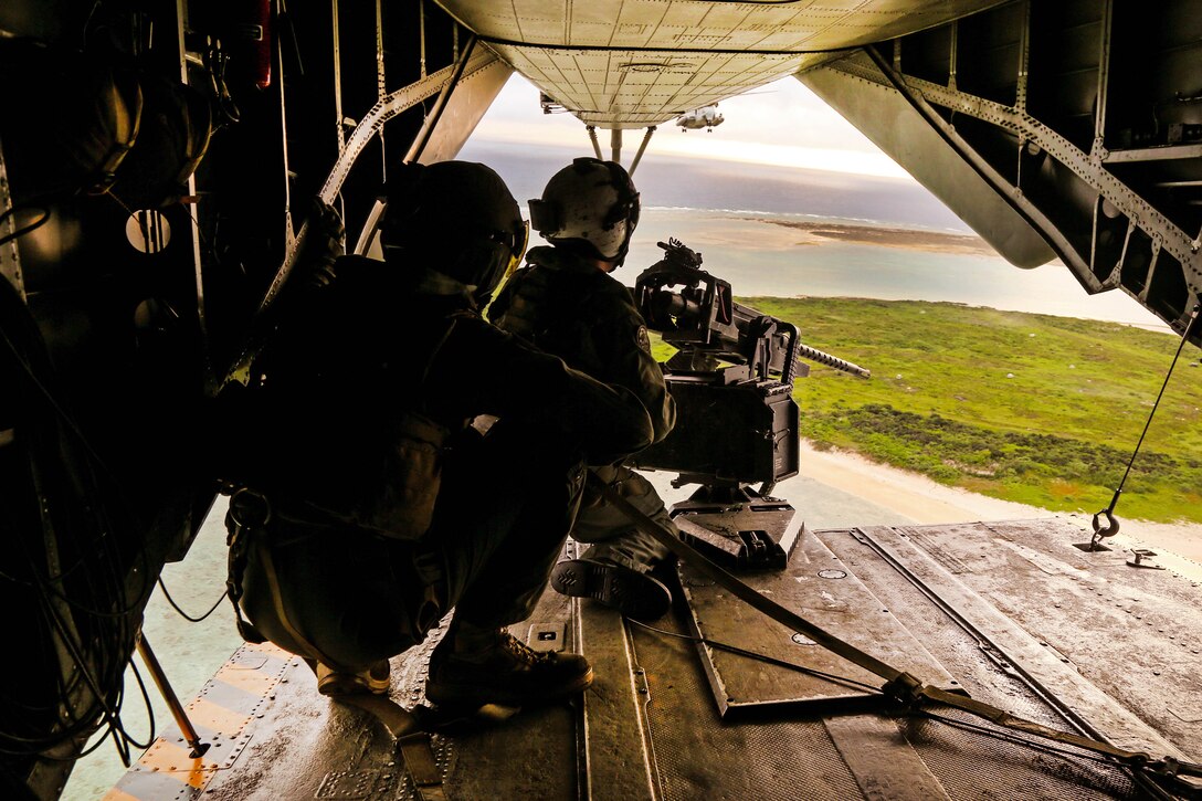 A Marine prepares to fire a M2 .50 caliber machine gun from the tail ramp of a CH-53E Super Stallion helicopter during aerial gunnery training over Okinawa, Japan, June 27, 2017. Marine Corps photo by Sgt. Rebecca L. Floto