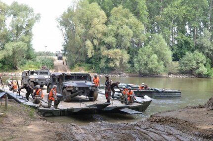 GYOR, Hungary - Military vehicles belonging to 1st squadron, 2nd Cavalry Regiment, Vilseck, Germany, are ferried over the Danube River during a rehearsal river crossing at Gyor, July 4. The ferry is employed by 837th Brigade Engineer Battalion, Ohio National Guard, and 37th Engineer Regiment, Hungarian Ground Forces. The exercise, Szentes Axe, a Hungarian-led exercise under Saber Guardian, facilitates the freedom of movement for 2nd Cavalry Regiment as the unit moves into Romania for more training with NATO Allies and partners. Saber Guardian is the largest exercise in the Black Sea Region and will take place in three countries. (U.S. Army photo by Sgt. Shiloh Capers) (Photo Credit: Sgt. Shiloh Capers)