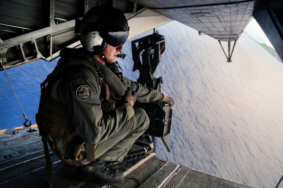 Marine Corps Sgt. Cole Bennick scans the water below from the tail ramp of a CH-53E Super Stallion helicopter after participating in aerial gunnery training over Okinawa, Japan, June 27, 2017. Bennick is a crew chief assigned to Heavy Helicopter Squadron 462, 3rd Marine Aircraft Wing, 1st Marine Aircraft Wing. Marine Corps photo by Sgt. Rebecca L. Floto