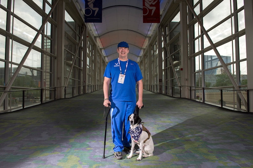Air Force veteran Tech Sgt. Eric Fisher and his dog Lola stand for photo at McCormick Place where several events in the 2017 Dept. of Defense Warrior Games are being held in Chicago June, 29, 2017.  The DoD Warrior Games are an annual event allowing wounded, ill and injured service members and veterans to compete in Paralympic-style sports. (DoD photo by EJ Hersom)