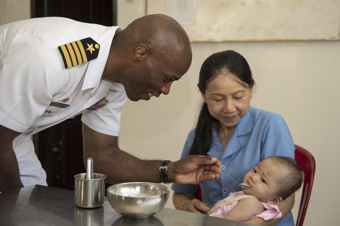Navy Capt. Lex Walker, commodore, Destroyer Squadron 7, assists a staff member caring for an infant at the Khanh Hoa Center for Social Protection during Naval Engagement Activity Vietnam 2017 in Nha Trang, Vietnam, July 6, 2017. Navy photo by Petty Officer 2nd Class Joshua Fulton