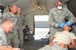 Tech Sgt. Dac Chaplin, 178th Medical Group dental assistant, marks notes for Lt. Col Simon Nguyen, 178th Wing Medical Group dental surgeon, during a dental exam for a soldier who reported dental pain during field exercises at the Pohakuloa Training Area, Hawaii. Airmen from the 178th Medical Group and 121st Medical Group participated in joint medical training while completing their annual training requirements, June 11-23, 2017.