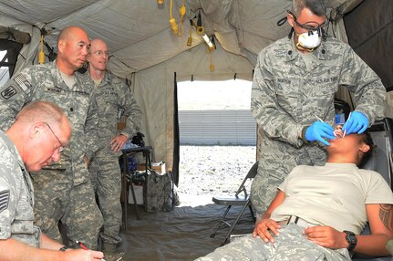 Tech Sgt. Dac Chaplin, 178th Medical Group dental assistant, marks notes for Lt. Col Simon Nguyen, 178th Wing Medical Group dental surgeon, during a dental exam for a soldier who reported dental pain during field exercises at the Pohakuloa Training Area, Hawaii. Airmen from the 178th Medical Group and 121st Medical Group participated in joint medical training while completing their annual training requirements, June 11-23, 2017.