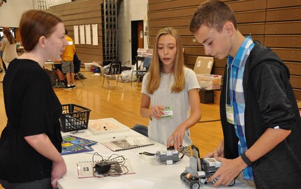 KING GEORGE, Va. (June 28, 2017) - Middle school students brief their mentor, Jennifer Testa, on how they overcame technical hurdles to ensure the robot they built will expeditiously locate mines and deliver supplies to troops in fictitious scenarios at the 2017 Naval Surface Warfare Center Dahlgren Division (NSWCDD)-sponsored STEM Summer Academy. Testa spoke to parents attending the event about STEM (science, technology, engineering and mathematics) opportunities, including high school and college internships available throughout Navy and Department of Defense laboratories. This year, STEM campers caught a glimpse of the real-world applications during their NSWCDD tour, featuring technologies and facilities that included the electromagnetic railgun, laser lethality laboratory, the Potomac River Test Range, vehicle integration technologies, and the F-14 ground plane used for testing and evaluating hazards of electromagnetic radiation to ordnance.