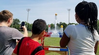 KING GEORGE. Va. (June 29, 2017) - Middle school students fire water rockets they built with fuel load to maximize height at the 2017 Naval Surface Warfare Center Dahlgren Division sponsored STEM Summer Academy, held June 26-30. Camp activities also included ten robotic challenges; exploring epidemiology; building and destructively testing a tower from balsa wood with the goal of maximizing the strength to weight ratio; predicting the number of each color of M&Ms in a large bag after compiling statistics on numbers in smaller bags; and building a boat out of foil and straws with the aim of maximizing its cargo carrying capacity.