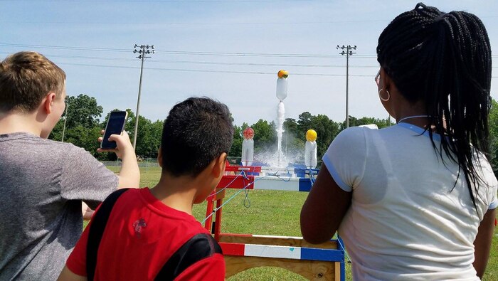 KING GEORGE. Va. (June 29, 2017) - Middle school students fire water rockets they built with fuel load to maximize height at the 2017 Naval Surface Warfare Center Dahlgren Division sponsored STEM Summer Academy, held June 26-30. Camp activities also included ten robotic challenges; exploring epidemiology; building and destructively testing a tower from balsa wood with the goal of maximizing the strength to weight ratio; predicting the number of each color of M&Ms in a large bag after compiling statistics on numbers in smaller bags; and building a boat out of foil and straws with the aim of maximizing its cargo carrying capacity.