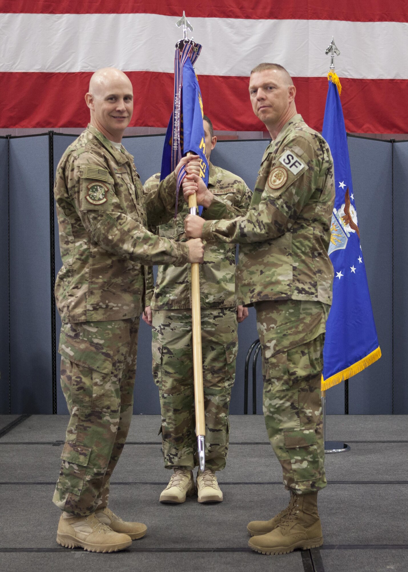 Col. John Grimm, 90th Security Forces Group commander, passes the guidon to Lt. Col. Anthony McCarty, 90th Missile Security Forces Squadron commander, during the 90th MSFS change of command ceremony July 6, 2017, as Senior Master Sgt. Rory Peters, 90th MSFS first sergeant, stands in the background on F.E. Warren Air Force Base, Wyo. The ceremony signified the transition of command from Lt. Col. James Hughes to McCarty. (U.S. Air Force photo by Lan Kim)