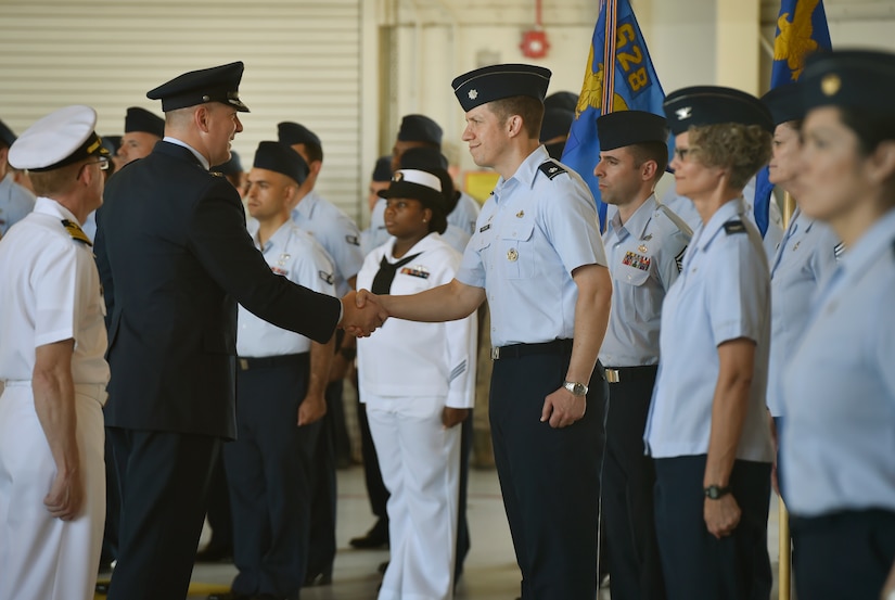 Col. Robert Lyman, left, 628th Air Base Wing and Joint Base Charleston outgoing commander, shakes the hand of Lt. Col. Bryan Collins, right, 628th Comptroller Squadron commander, during a wing inspection as part of a change of command ceremony at Nose Dock 2 here, July 6, 2017. Col. Jeffrey Nelson took command from Col. Robert Lyman, during the ceremony. U.S. Air Force Maj. Gen. Christopher Bence, U.S. Air Force Expeditionary Center commander, presided over the ceremony. 