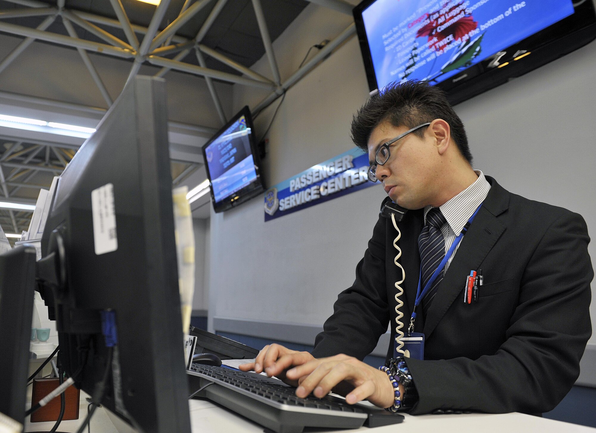 Tomokazu Arakaki, 733rd Air Mobility Squadron passenger service agent, helps a customer over the phone with outbound flight schedules at the 733rd AMS Passenger Terminal, April 1, 2016, at Kadena Air Base, Japan. Arakaki aims to pass Eiken pre-1st grade test (=Practical English Proficiency test while he is working at the 733rd AMS. (U.S. Air Force photo by Naoto Anazawa)