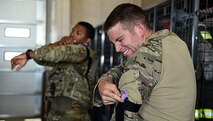 Senior Airman Louis Simpson and Staff Sgt. Josef Miller, 22nd Civil Engineer Squadron Explosive Ordnance Disposal technicians, apply tourniquets, June 26, 2017, at McConnell Air Force Base, Kan. During Tactical Combat Casualty Care training, Simpson and Miller experienced how tight a tourniquet can get when adjusted on a limb correctly. (U.S. Air Force photo/Airman 1st Class Alan Ricker)