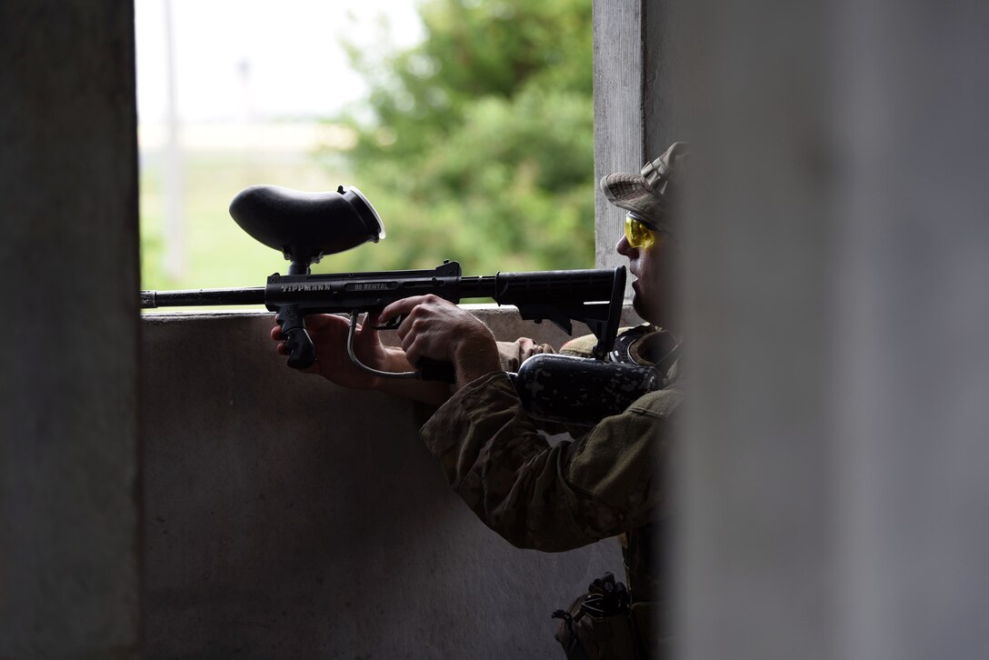 Staff Sgt. Brant Lundberg, 22nd Civil Engineer Squadron Explosive Ordnance Disposal technician, takes cover during a Tactical Combat Casualty Care training, June 27, 2017, at the mock village on McConnell Air Force Base, Kan. The mock-village scenario allowed Airmen to react to uncertain circumstances in an urban setting and better prepared them for possible real-world situations. (U.S. Air Force photo/Airman 1st Class Alan Ricker)