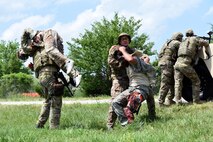 Airmen assigned to the 22nd Civil Engineer Squadron Explosive Ordnance Disposal flight rescue injured personnel during a training scenario, June 27, 2017, at McConnell Air Force Base, Kan. Role-players acted as victims and shooters to allow Airmen to have realistic reactions to combat situations. (U.S. Air Force photo/Airman 1st Class Alan Ricker)