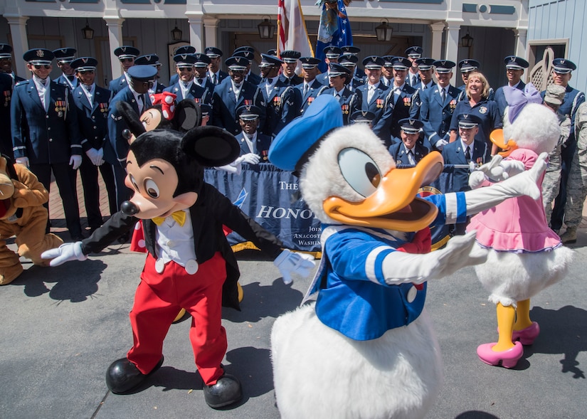 Disney characters run in front of a U.S. Air Force Honor Guard group photo at Disneyland in Anaheim, Calif., June 29, 2017. The “Ambassadors in Blue” demonstrated drill routines during their recent tour of Southern California where they also performed at Sea World, Disney’s California Adventure Park, and Mission Beach from June 27 to July 1. (U.S. Air Force photo by Senior Airman Jordyn Fetter)