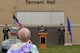 Lt. Col. Jennifer Saraceno, 97th Intelligence Squadron commander, officially unveils Tennant Hall on the squadron headquarters building during a ceremony here June 30. The facility was dedicated in honor of retired Chief Master Sgt. Thomas H. Tennant who played a major role establishing intelligence, surveillance and reconnaissance operations in multiple units which later became the 97th IS. (U.S. Air Force photo by Charles Haymond)