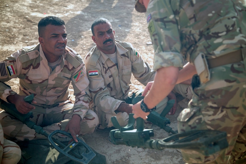 A U.K. army trainer explains the parts of the Vallon metal detector during mine detection training at the Besmaya Range Complex Iraq, July 2, 2017. This training is part of the overall Combined Joint Task Force - Operation Inherent Resolve building partner capacity mission which focuses on training and improving the capability of partnered forces fighting ISIS. CJTF-OIR is the global Coalition to defeat ISIS in Iraq and Syria. (U.S. Army photo by Cpl. Tracy McKithern)