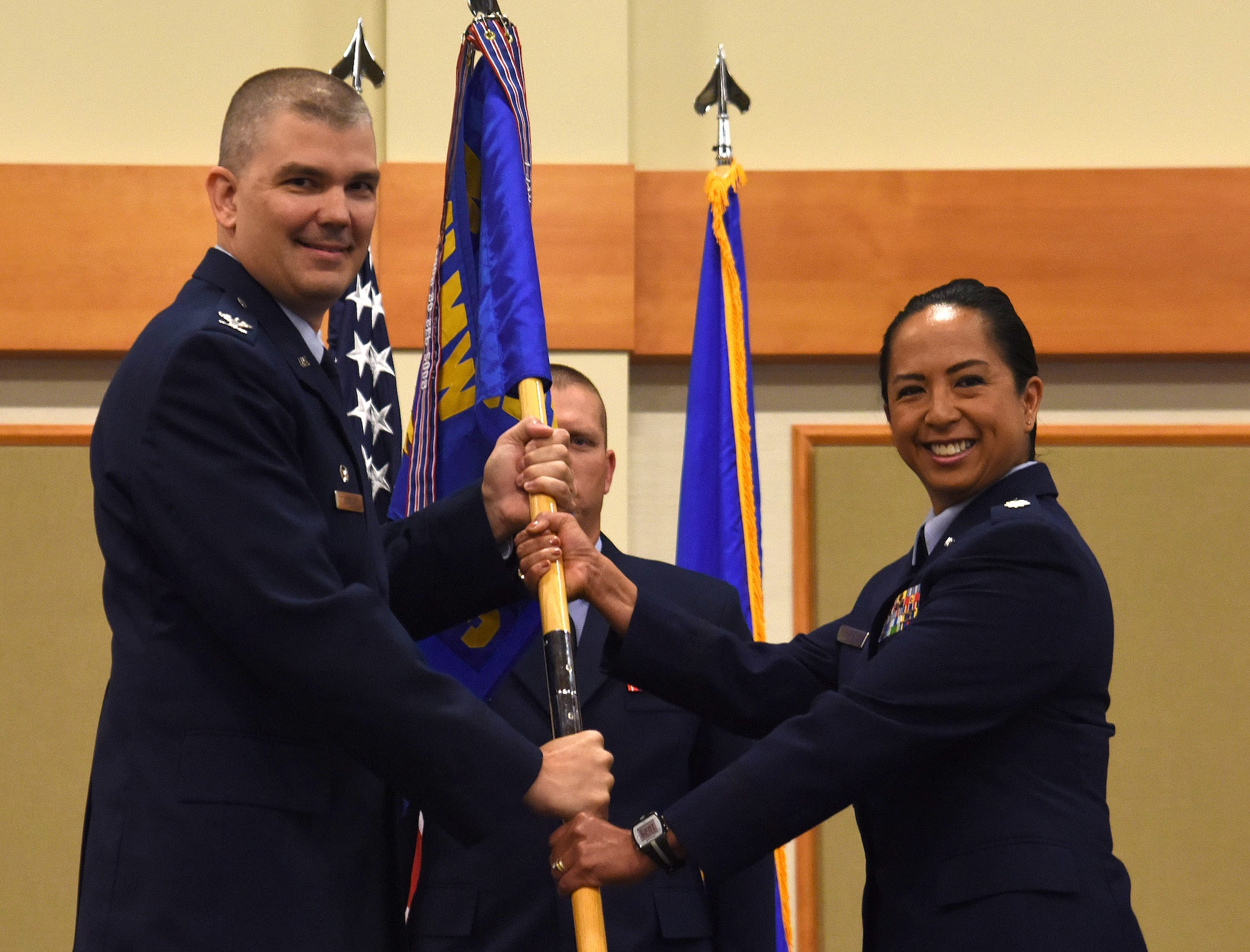Lt. Col. Marybeth Luna, right, accepts command of the 341st Medical Support Squadron from Col. Craig Forcum, 341st Medical Group commander, during a change of command ceremony at the Grizzly Bend, Malmstrom Air Force Base, Montana, July 6, 2017. Master Sgt. Jason Whitehead, 341st MDG first sergeant, looks on. (U.S. Air Force photo/Senior Airman Jaeda Tookes)