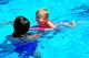 A Team Shaw child uses a board as a floatation device while a junior lifeguard volunteer holds her at the 20th Force Support Squadron Woodland Pool at Shaw Air Force Base, S.C., July 6, 2017. The child learned to kick water while supervised during a swim lesson, which was part of a six-day class. (U.S. Air Force photo by Airman 1st Class Kathryn R.C. Reaves)
