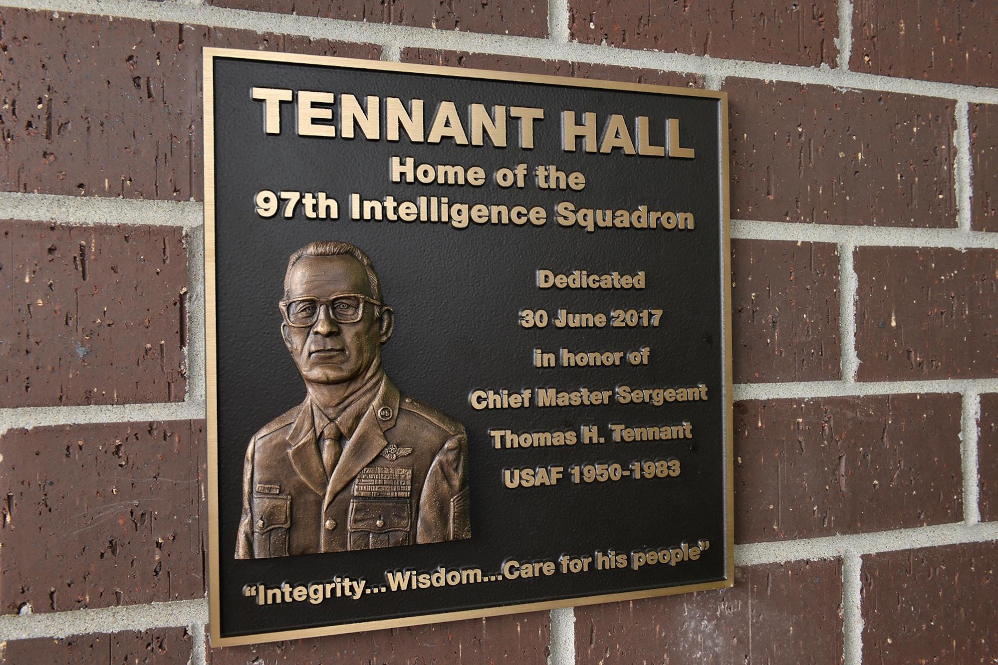 A plaque highlighting the career of retired Chief Master Sgt. Thomas H. Tennant is on display at Tennant Hall, the home of the 97th Intelligence Squadron here. The facility was dedicated to Tennant during a ceremony on June 30. (U.S. Air Force photo by Charles Haymond)