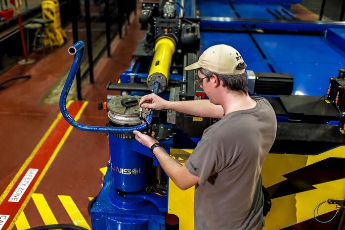 NNSY Pipe Bender Work Leader Tommy Whitaker demonstrates the shipyard's new pipe bending machine.