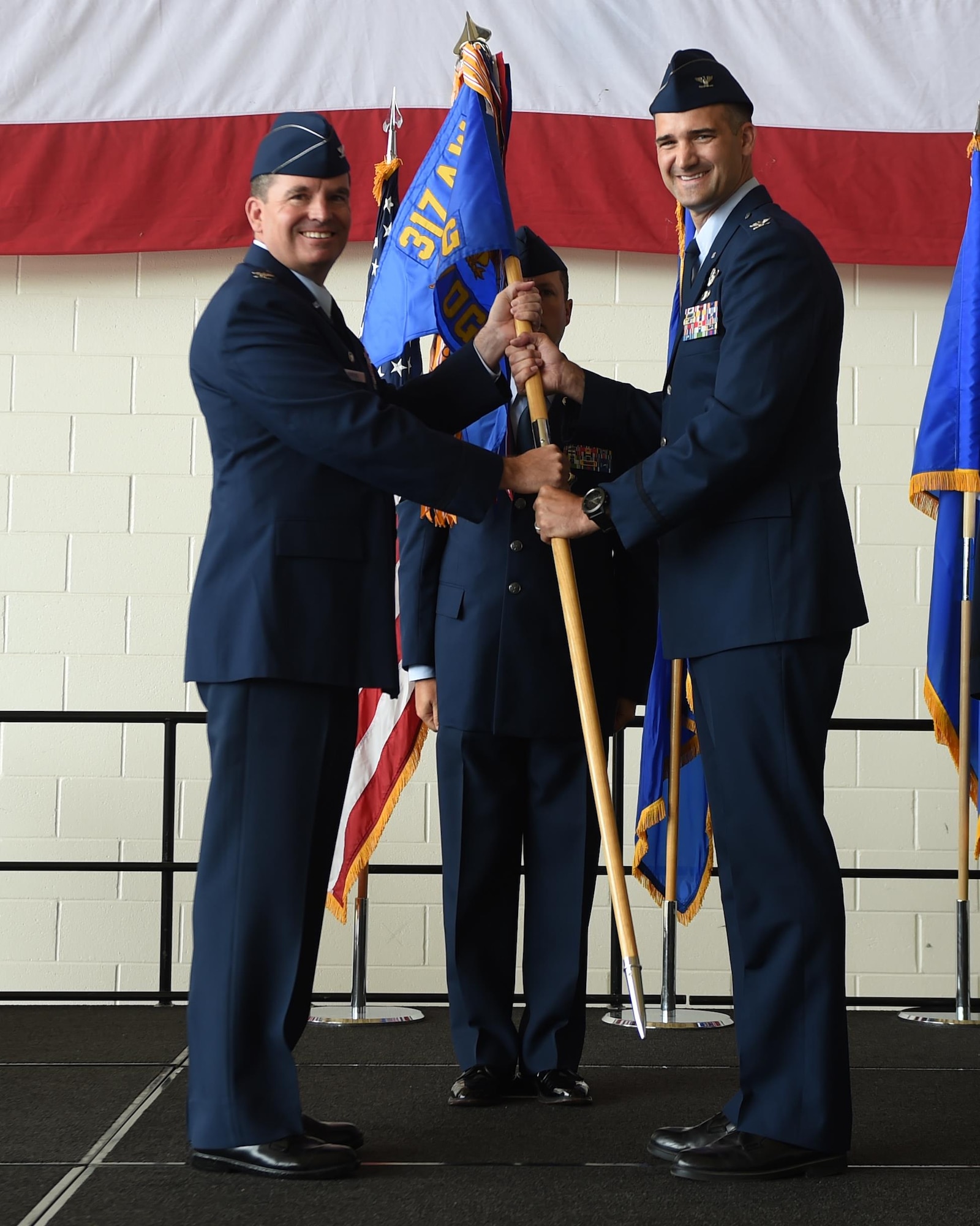 U.S. Air Force Col. David Owens, left, 317th Airlift Wing commander, hands a guidon to Col. James Hackbarth, 317th Operation Support Group commander, at Dyess Air Force Base, Texas July, 6, 2017. The 317th OSG was created in support of the newly activated 317th Airlift Wing. (U.S. Air Force photo by Senior Airman Alexander Guerrero)