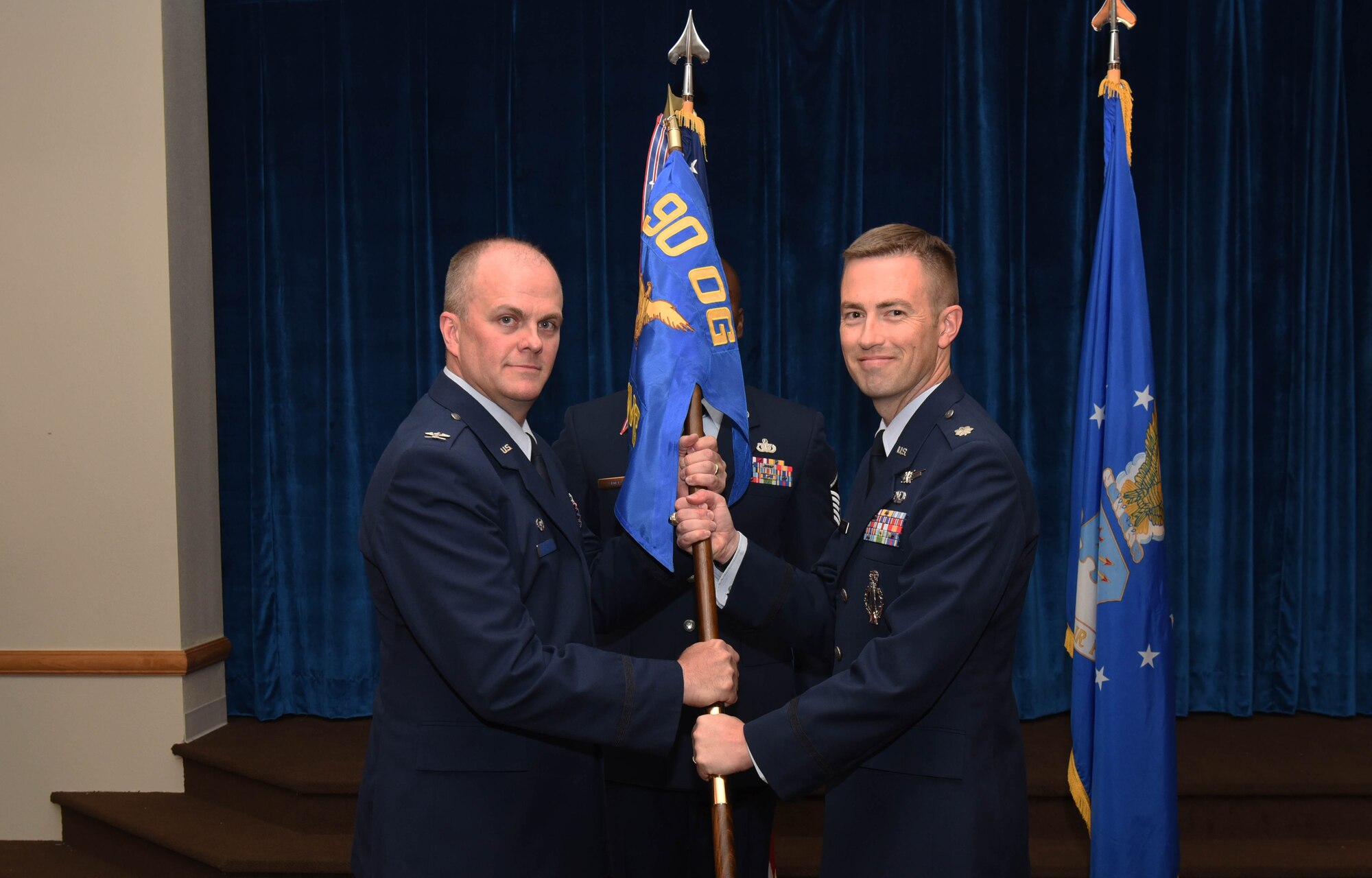 Col. Todd Sauls, 90th Operations Group commander, passes the guidon to Lt. Col. George Chapman, 320th Missile Squadron commander, during the 320th MS change of command ceremony at F.E. Warren Air Force Base, Wyo., July 5, 2017. The ceremony signified the transition of command from Lt. Col. Russell Williford. (U.S. Air Force photo by Airman 1st Class Breanna Carter)