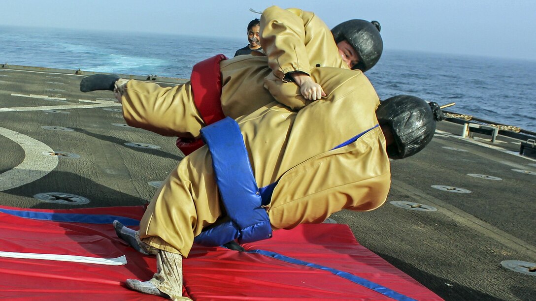 Marines wrestle in sumo suits during a steel beach picnic aboard the amphibious dock landing ship USS Carter Hall in the 5th Fleet area of operations, July 1, 2017. The ship is supporting maritime security operations to reassure allies and partners. Navy photo by Petty Officer 3rd Class Jelani J. McRaeQuiles