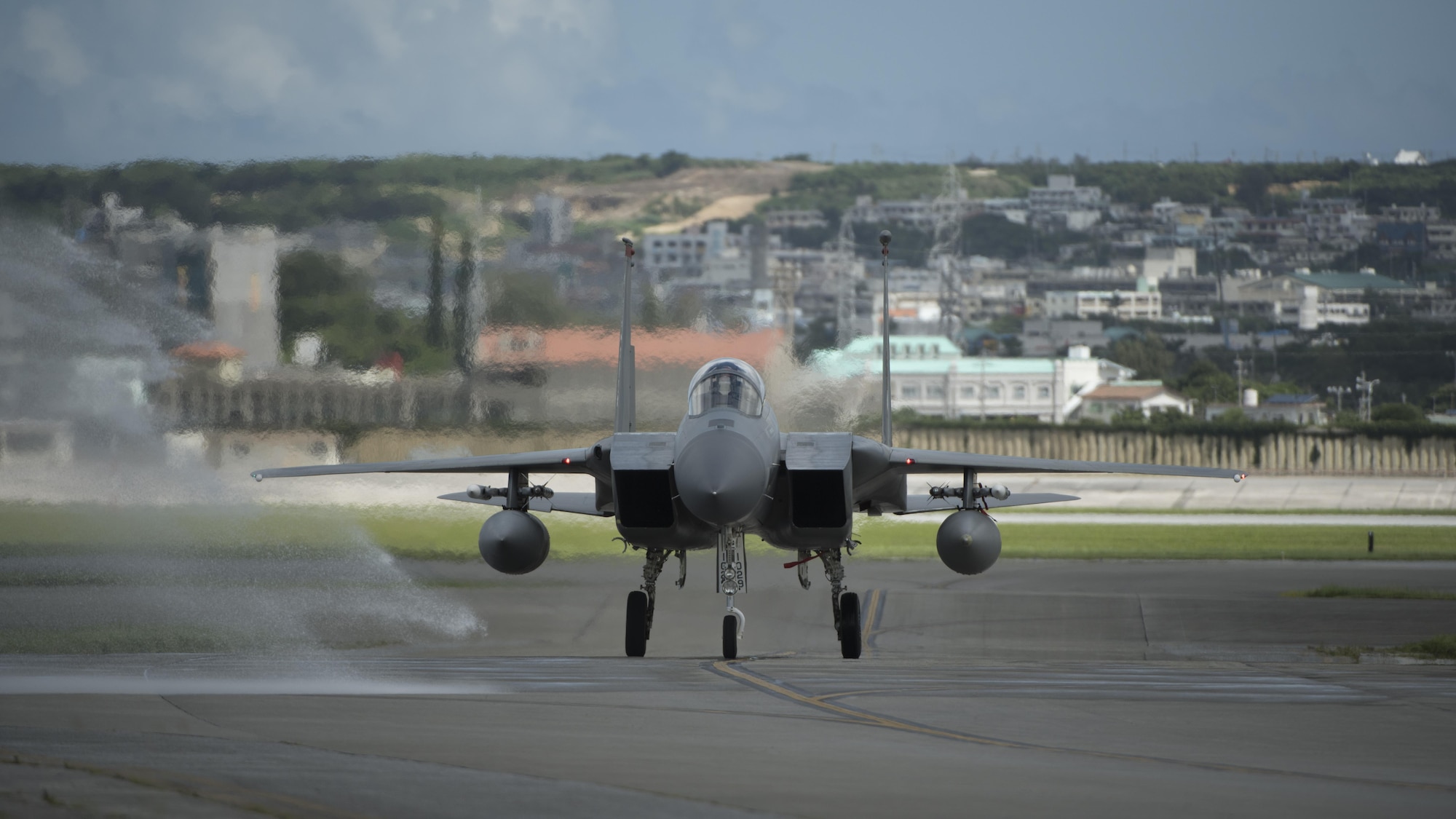 U.S. Air Force Brig. Gen. Barry Cornish, 18th Wing commander, taxis an F-15 Eagle from the 67th Fighter Squadron after his final flight June 29, 2017, at Kadena Air Base, Japan.  As part of the tradition for a final flight, the pilot receives a “bird bath” by firetrucks on the flightline. (U.S. Air Force photo/ Airman 1st Class Greg Erwin)