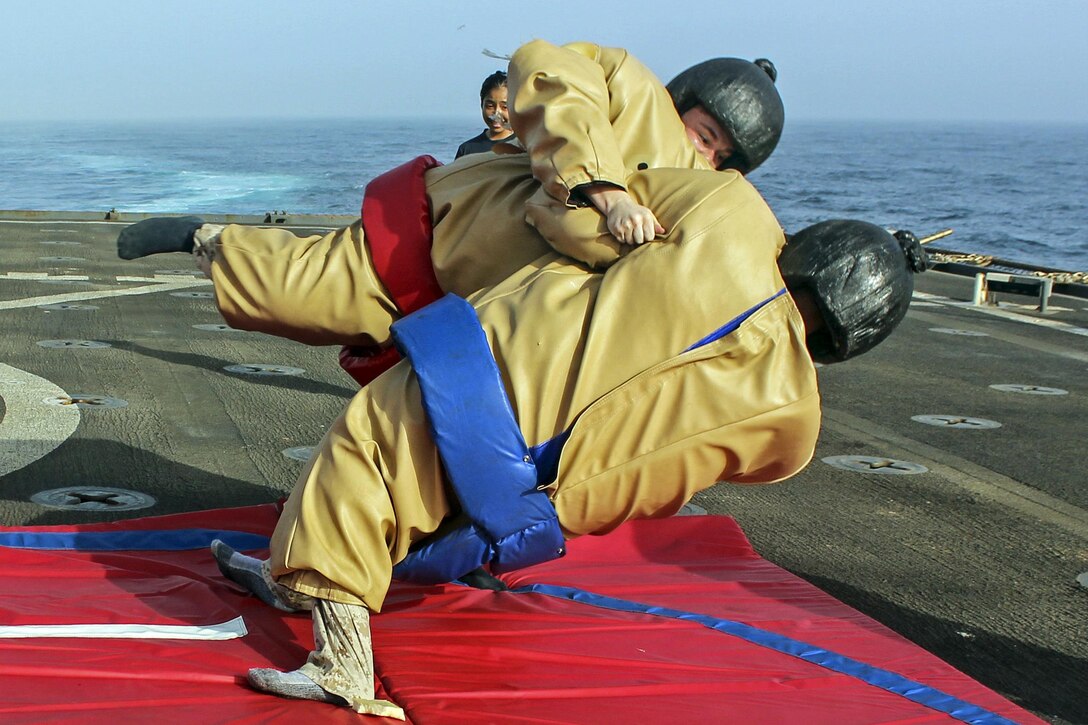 Marines wrestle in sumo suits during a steel beach picnic aboard the amphibious dock landing ship USS Carter Hall in the 5th Fleet area of operations, July 1, 2017. The ship is supporting maritime security operations to reassure allies and partners. Navy photo by Petty Officer 3rd Class Jelani J. McRaeQuiles