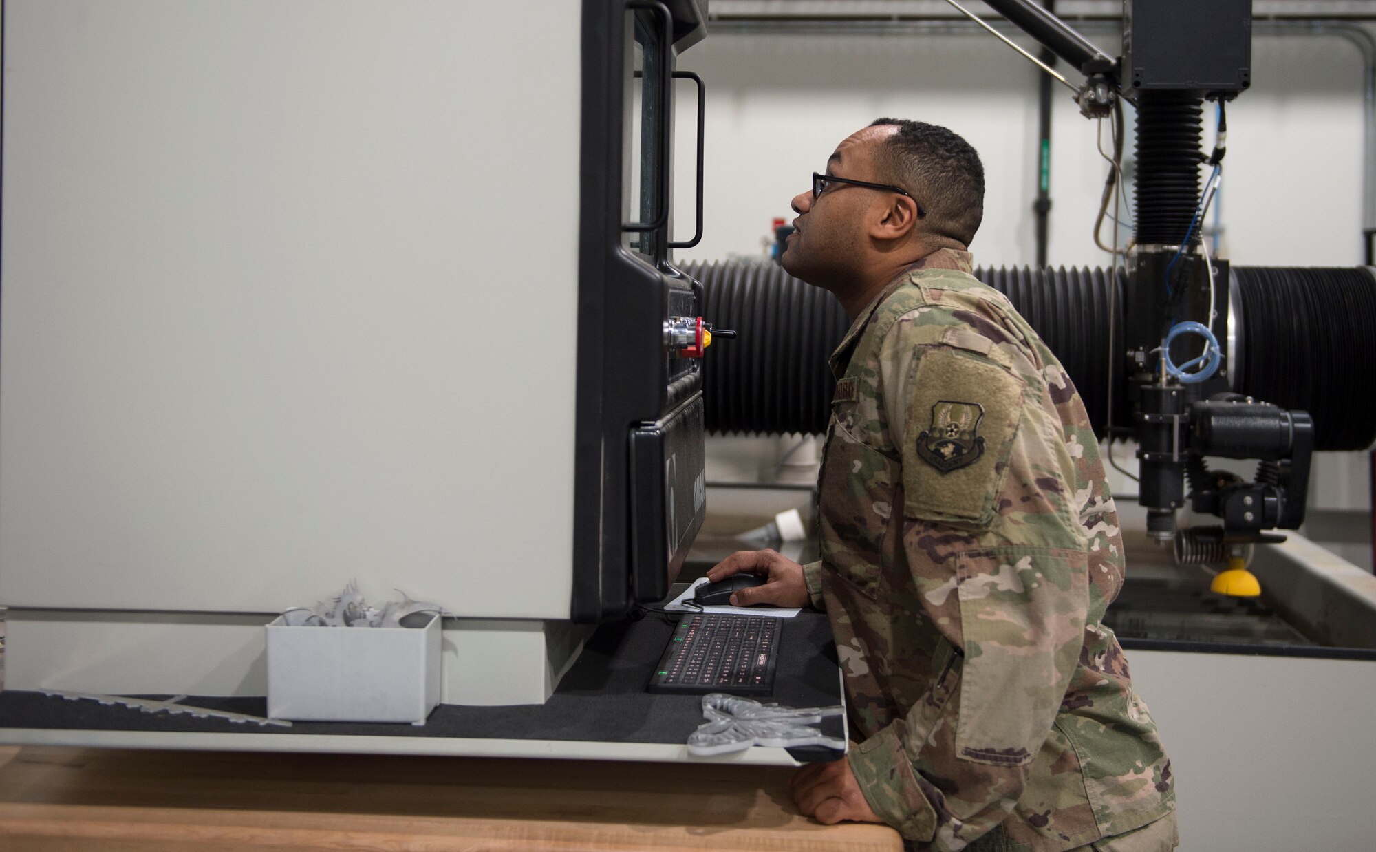 U.S. Air Force Master Sgt. Anwar Simmons, section chief with the 379th Expeditionary Maintenance Squadron, sets up the abrasive waterjet cutting machine at Al Udeid Air Base, Qatar, June 5, 2017. The abrasive waterjet cutting machine allows the airmen to create a wide range of aircraft parts or tools needed to complete the mission in an expedited and a cost effective manner. (U.S. Air Force photo by Tech. Sgt. Amy M. Lovgren)