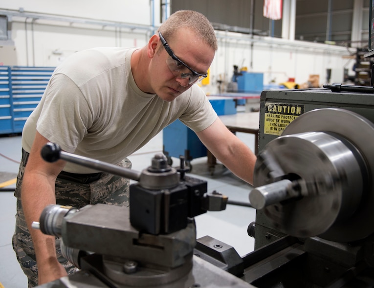 U.S. Air Force Staff Andrew Walker, a fabrication specialist with the 379th Expeditionary Maintenance Squadron uses a manual lathe to create a cylindrical part June 5, 2017, at Al Udeid Air Base, Qatar. Walker is part of a team of machinists and welders which are trained on a wide range of manual and computer numerical controlled machines to manufacture and repair aircraft components and support equipment. (U.S. Air Force photo by Tech. Sgt. Amy M. Lovgren)