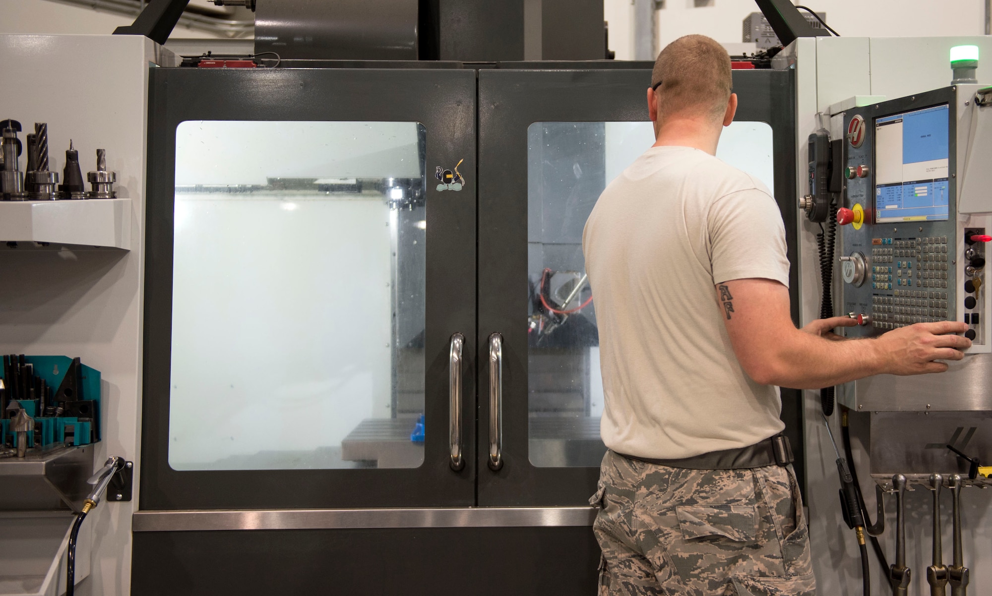 U.S. Air Force Staff Andrew Walker, a fabrication specialist with the 379th Expeditionary Maintenance Squadron uses a computer numerical control machine at Al Udeid Air Base, Qatar, June 5, 2017. The CNC allows Walker and other machinists to increase the speed of the manufacturing and reduce the wait time for new aircraft parts. (U.S. Air Force photo by Tech. Sgt. Amy M. Lovgren)