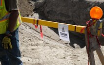 A sign marks an excavation area on Bagram Airfield, Afghanistan. Contractors at BAF are currently placing new waterlines. The 455th Air Expeditionary Wing Safety Office teamed up with the contractors and the 455th Expeditionary Civil Engineer Squadron to review safety measures and techniques for an such an environment. The event ensured U.S Airmen could meet the safety challenges of underground construction projects. (U.S. Air Force photo by Capt. Keenan Kunst)