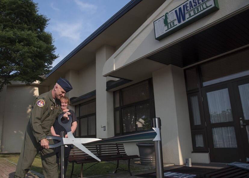 U.S. Air Force Col. R. Scott Jobe, the 35th Fighter Wing commander, cuts a ribbon during the grand opening of the Wild Weasels' Bar & Grill, at Misawa Air Base, Japan, July 7, 2017.  The 35 Force Support Squadron established the eatery to satisfy Misawa AB residents' request for an American style dine-in restaurant. (U.S. Air Force photo by Airman 1st Class Sadie Colbert)