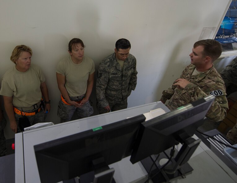 U.S. Air Force Staff Sgt. Brent Points, a journeyman with the 379th Expeditionary Civil Engineer Squadron Explosive Ordnance Disposal Flight, right, talks to airmen with the 8th Expeditionary Air Mobility Squadron on what to look for while screening luggage at Al Udeid Air Base, Qatar, June 14, 2017. The airmen are enhancing their knowledge on safety precautions for inspection of personnel luggage as they go through the passenger terminal. (U.S. Air Force photo by Tech. Sgt. Amy M. Lovgren)