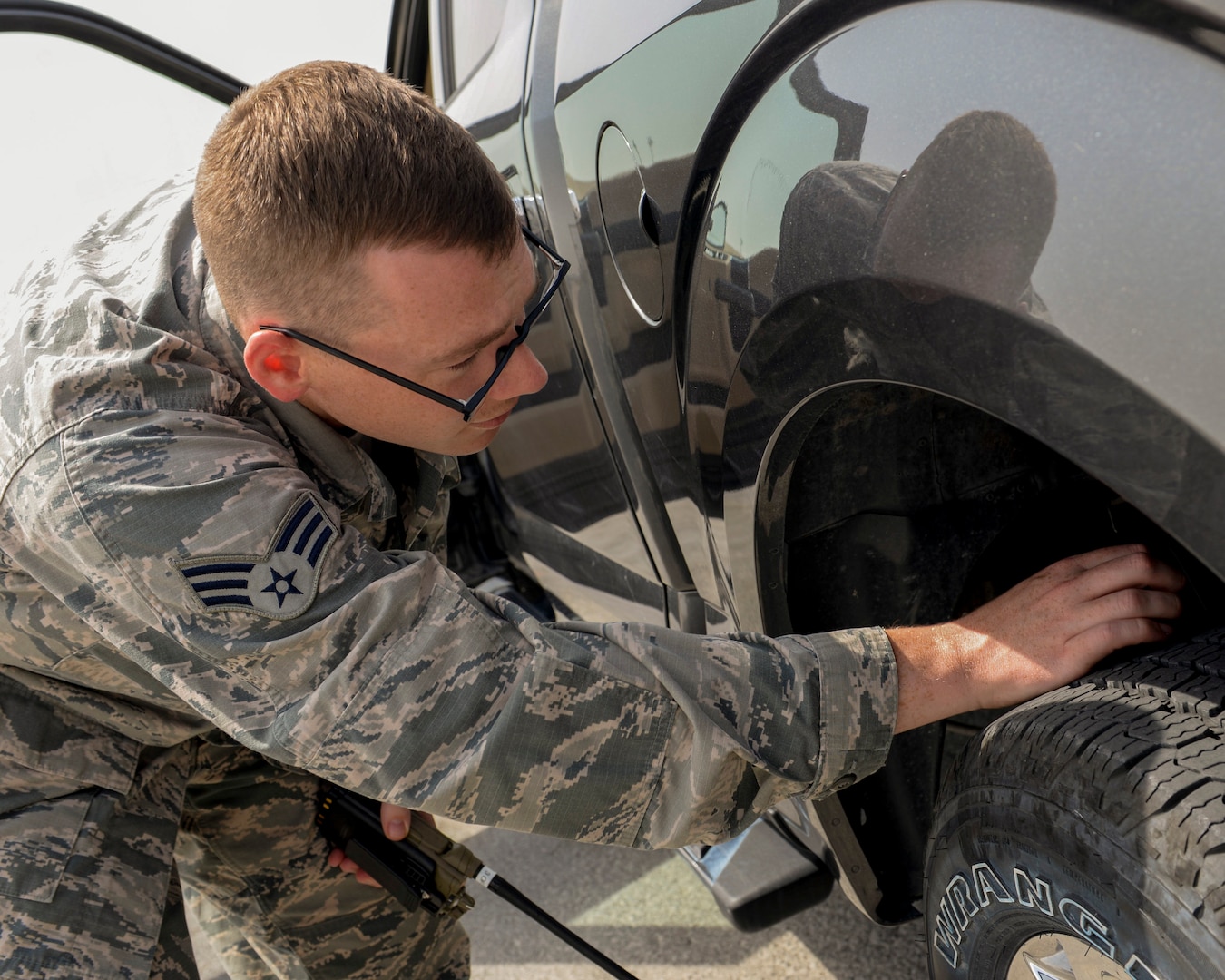 U.S. Air Force Senior Airman Thomas Smith, airfield management shift lead assigned to the 379th Expeditionary Office of Strategic Services, checks his vehicle's tire treads for debris by completing a foreign object damage (FOD) check prior to driving onto the runway at Al Udeid, Air Force Base, Qatar, June 7, 2017. Airfield Management oversees more than 20 million square feet of airfield at Al Udeid in addition to overseeing the airfield driving program and filing all flight plans for flights arriving to and departing from the base. (U.S. Air National Guard photo by Tech. Sgt. Bradly A. Schneider/Released)