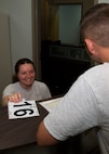 Senior Airman Courtney Sire, Fitness Assessment Cell physical training leader, hands an Airman their test number at the McAdoo Fitness Center on Minot Air Force Base, N.D., June 28, 2017. Squadron or unit PTLs can be assigned to FAC duty for a month. (U.S. Air Force photo by Airman 1st Class Alyssa M. Akers)