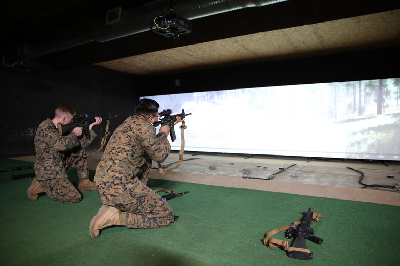 Cpls. Noah Paul and Geovanni Martinez, combat marksmanship coaches and Indoor Simulated Marksmanship Trainer operators, fire M27 Infantry Automatic Rifles at the ISMT III training range aboard Marine Corps Base Quantico, Virginia. The M27 is one of three new weapons offered with the ISMT III. The M27 comes with enhanced squad day optics, which enable Marines to see their screens more clearly in a virtual environment. The ISMT III adds three new weapons, 3-D imagery, and enhanced training modes, giving Marines a better, more realistic training experience as they prepare for the complexities of modern warfare. (U.S. Marine Corps photo by Ashley Calingo)