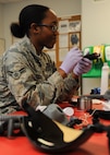 Airman 1st Class Shaquita Puckett, 5th Operations Support Squadron aircrew flight equipment technician, cleans a CRU-60/P connector at Minot Air Force Base, N.D., June 29, 2017. The CRU-60/P connects the aircraft oxygen supply-hose to aircrew members’ breathing masks. (U.S. Air Force Photo by Airman 1st Class Jessica Weissman)